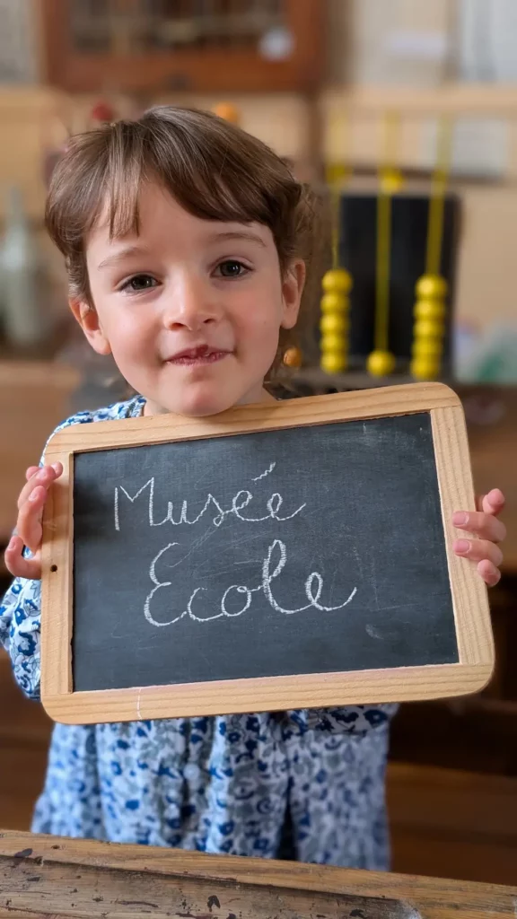 Petite fille devant le panneau du Musée école d’Unverre dans le Grand Châteaudun